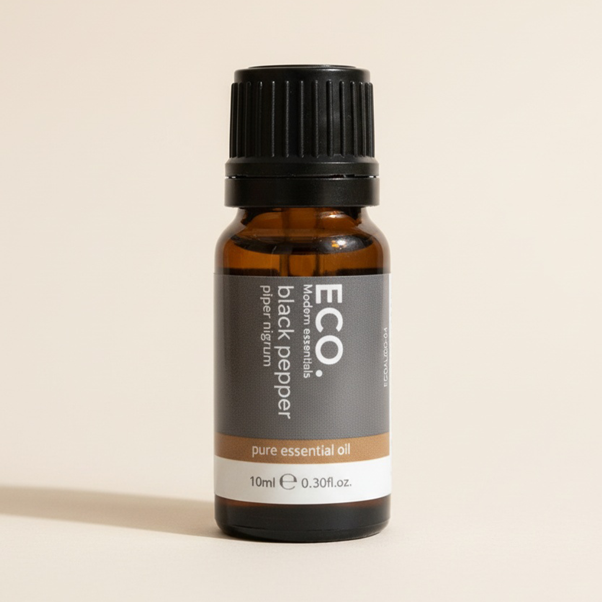Brown essential oil bottle with black cap on a beige background