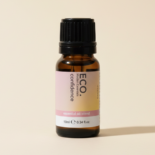 Bottle of Eco Confidence essential oil blend on a beige background