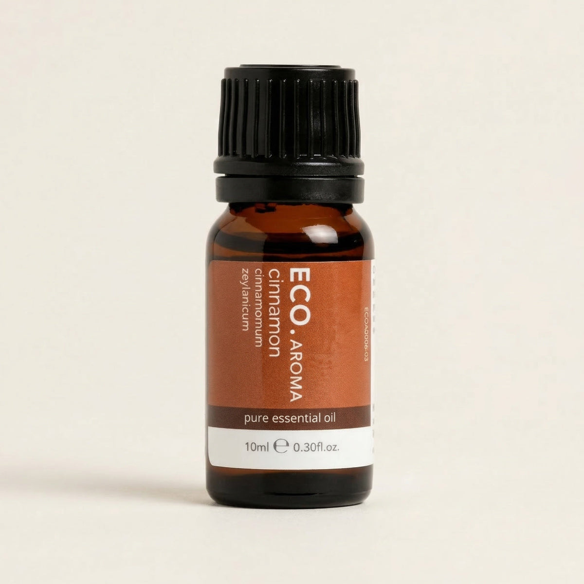 Brown essential oil bottle with black cap on a beige background