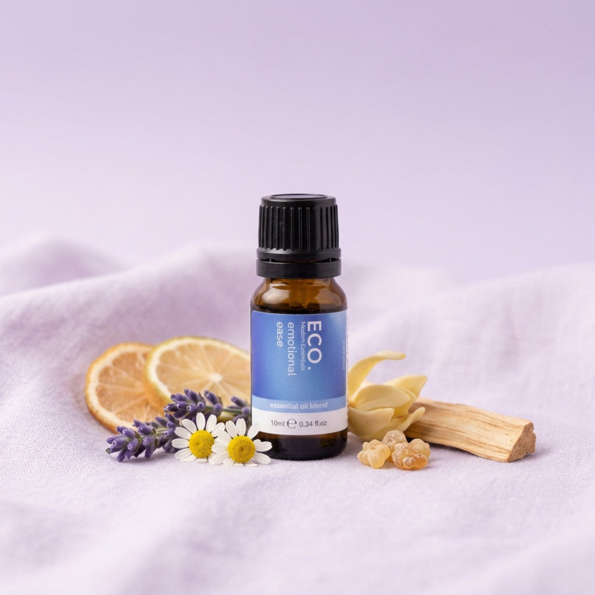Bottle of ECO essential oil with herbs and flowers on a light purple background