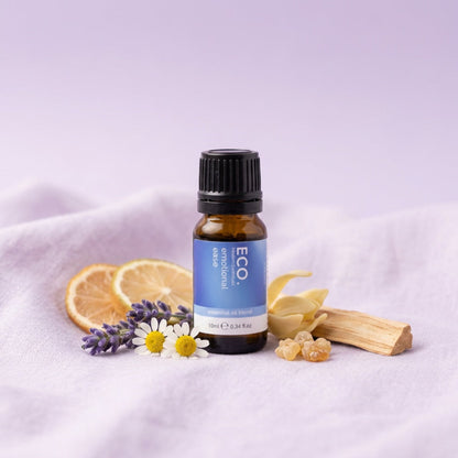 Bottle of ECO essential oil with herbs and flowers on a light purple background