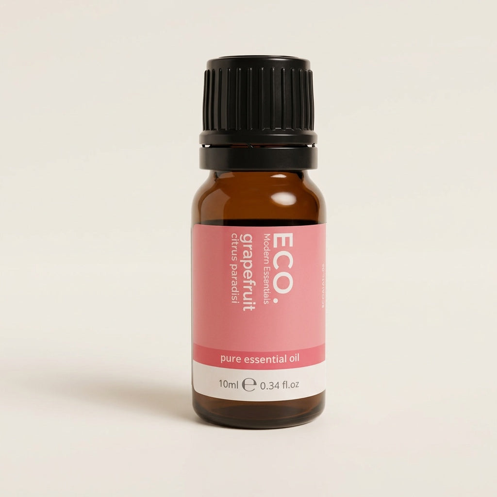 Bottle of grapefruit essential oil with a pink label on a beige background