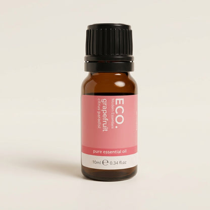 Bottle of grapefruit essential oil with a pink label on a beige background