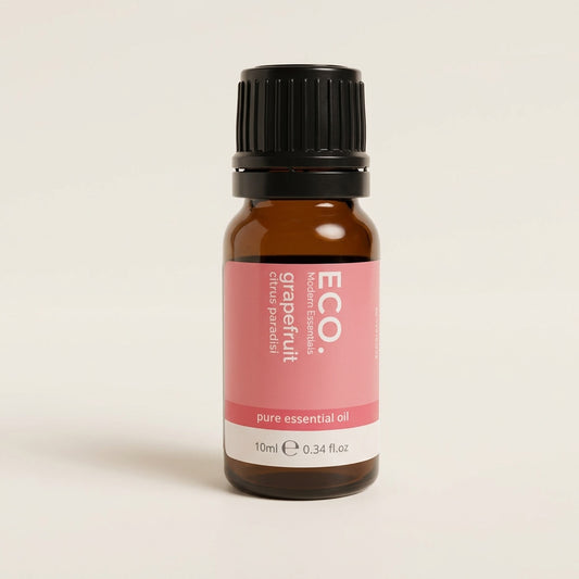 Bottle of grapefruit essential oil with a pink label on a beige background