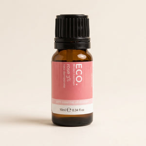 Bottle of ECO rose essential oil on a beige background