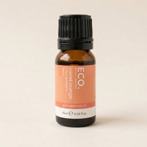 Bottle of ECO sweet orange essential oil on a beige background