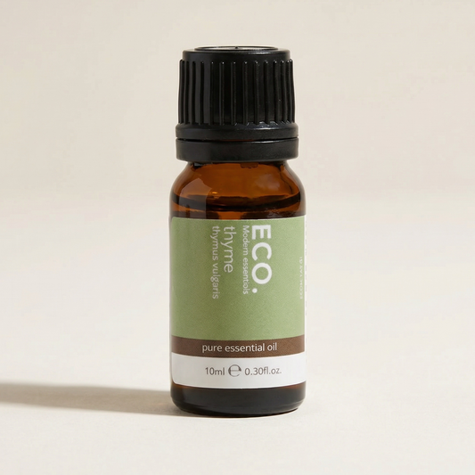 Brown glass bottle of ECO thyme essential oil on a beige background