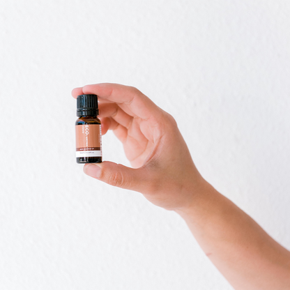 Hand holding Clove bud essential oil bottle