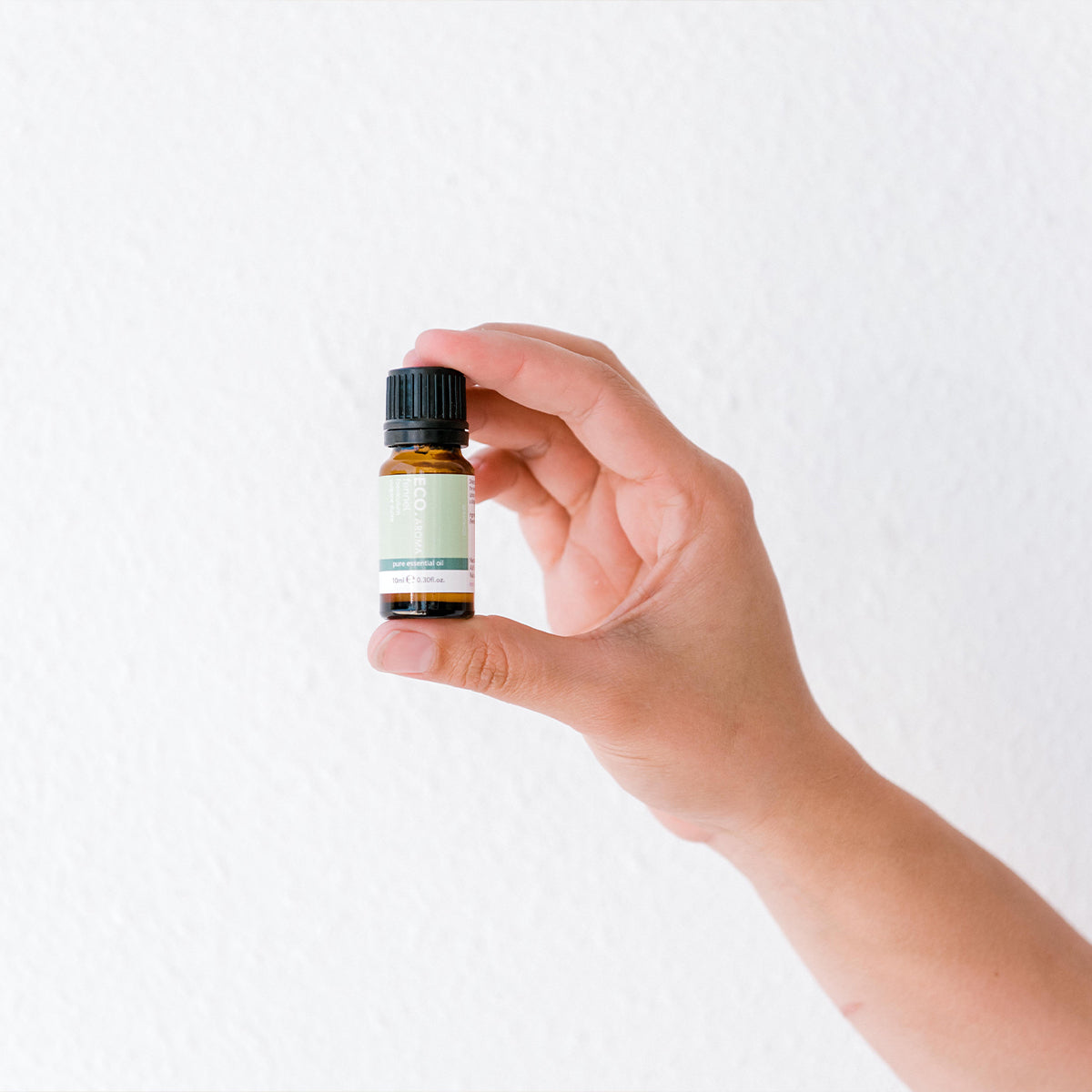 Hand holding Fennel essential oil bottle