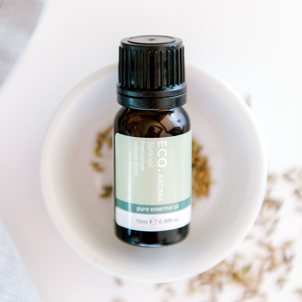 Fennel oil with fennel seeds in the background