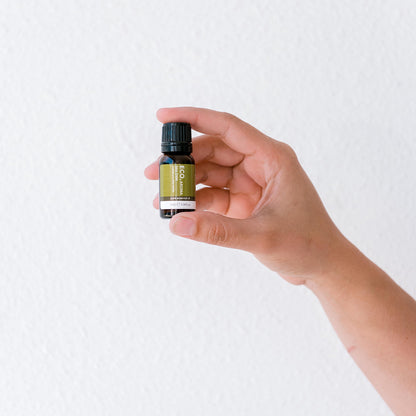 Hand holding Tea Tree essential oil bottle